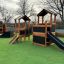 Knight's Castle Nature playhouse with slide v prostředí hřiště'