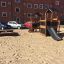 Knight's Castle Nature playhouse with slide v pískové části hřiště s cihlovou bytovou budo
