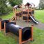 Knight's Castle Nature playhouse with slide a tunely v parku.