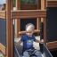 Dítě sjíždí po skluzavce Knight's Castle Nature playhouse with slide.