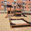 Tower Nature wooden playhouse with slide v písčité části hřiště