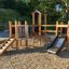 Fortress Nature playhouse with slide v prostředí hřiště