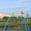 Hřiště s houpačkou Silver Single Swing (BNS) s moderním kruhovým designem sedátka.
