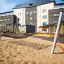Hammock v prostoru hřiště s moderní školní budovou v pozadí