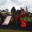 Mastodon castle with slide na hřišti s hrajícími si dětmi