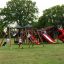 Děti si hrají na hřišti Mastodon castle with slide.