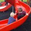 Děti si hrají na červené skluzavce Mastodon castle with slide.