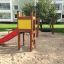 Toddler Tower Slide s červenou skluzavkou a žlutým panelem na hřišti.