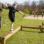 Děti si hrají na balančních kladinách Classic Nature Trim Trail v parku.