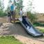 Děti si hrají na Hill Slide Wide h150 ve venkovním parku.