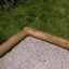 Dřevěný roh 5-angle palisade sandbox na trávě.