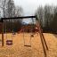 Swing Frame (double swing) na hřišti s dřevěnou štěpkou a skluzavkou v pozadí