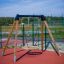 Swing Frame (single swing, wide) s dřevěnými sloupky a kruhovým sedátkem houpačky na hřišti