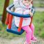 Miminko sedící v modro-červené Swing seat: Baby seat.