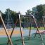 Swing seat: Safety seat na hřišti s lezeckou konstrukcí a dalším herním vybavením v pozadí