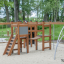 Panther wooden playhouse na hřišti s lezeckými konstrukcemi a žebříky'