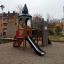 Tintagel playground castle se skluzavkou a lezeckou konstrukcí na hřišti v obytné oblasti.'