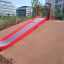 Hill Slide Wide SLW180 červená a šedá skluzavka na hřišti na svažitém kopci v městském parku