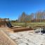 Dřevěné Sandpit s připojenou skluzavkou a lezeckými schody na venkovním hřišti.