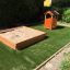 Dřevěný Sandpit s domečkem na zahradním hřišti.