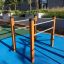 Parallel bar ve venkovní posilovně za slunečného dne.