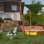 Sun Shade Triangle 3x3x3 Nature (Robinia) v prostoru hřiště s houpadlem, pískovištěm a pla