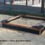 Dřevěné pískoviště s Dino sandbox base na venkovním hřišti.