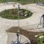 Venkovní fitness park s různými cvičebními prvky a zelení.