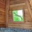 Wigwam wooden house interiér s výhledem z okna na zelené stromy
