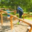 Děti si hrají na Climb Obstacle wooden ladder na venkovním hřišti.