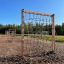 V-shape Net Large climbing net ve venkovním herním prostoru s povrchem z dřevní štěpky.