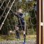 Muž leze na V-shape Net Large climbing net na venkovním hřišti.
