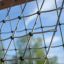 V-shape Net Large climbing net zblízka proti modré obloze.
