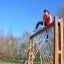 Žena leze na V-shape Net Large climbing net na venkovním hřišti.