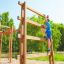 Chlapec leze na Step And Climb wooden ladder na hřišti.
