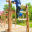 Děti lezou na Step And Climb wooden ladder na hřišti.