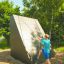 Chlapec šplhající na Climbing Ramp steel structure na venkovním hřišti.