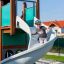 Majestic ship with slide na hřišti s chlapcem, který si užívá skluzavku