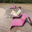 Muž sedící na venkovním růžovém Lounge chair za slunečného dne.