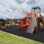 Twister castle with slide na hřišti s věží, červenou spirálovou skluzavkou a lezeckou stěnou