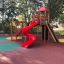 Twister castle with slide na barevném hřišti obklopeném stromy