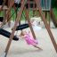 Dvě dívky si hrají na Double Swing (BNS 90cm) na hřišti.
