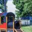 Herní konstrukce Train z dřeva a plastu se skluzavkou a tunelem.