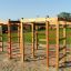 Dřevěný herní domek Activity Center s lezeckými konstrukcemi na hřišti.