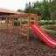 Dřevěná herní konstrukce s Activity Center with Slide v parku.