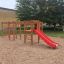 Activity Center with Slide na pískovém hřišti s lezeckými prvky a červenou skluzavkou