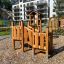 Smart Modern Nature wooden playhouse with slide před obytnými budovami