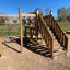 Moderní dřevěný domek na hraní s lezeckou sítí a schody na hřišti