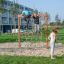 Děti lezou a hrají si na V-shape Net wooden playhouse v parku.