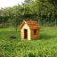 Dřevěné Nature Playhouse v travnaté zahradě.